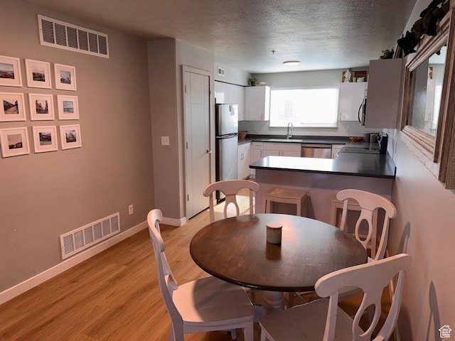 675 S 100 W Unit A203, Springville, UT 84663 - dining room featuring visible vents, a textured ceiling, light wood-style floors, and baseboards