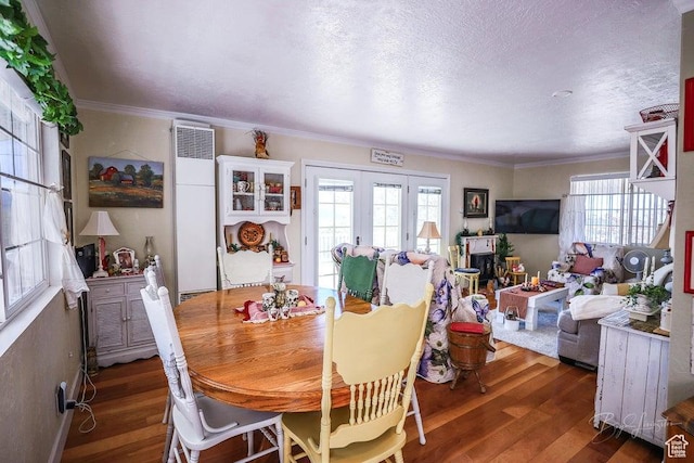 dining room featuring crown molding, french doors, hardwood / wood-style floors, and a heating unit