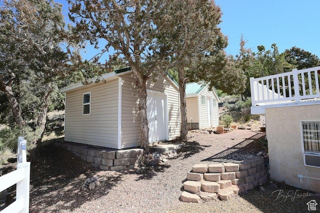 view of side of home featuring a shed and an outbuilding