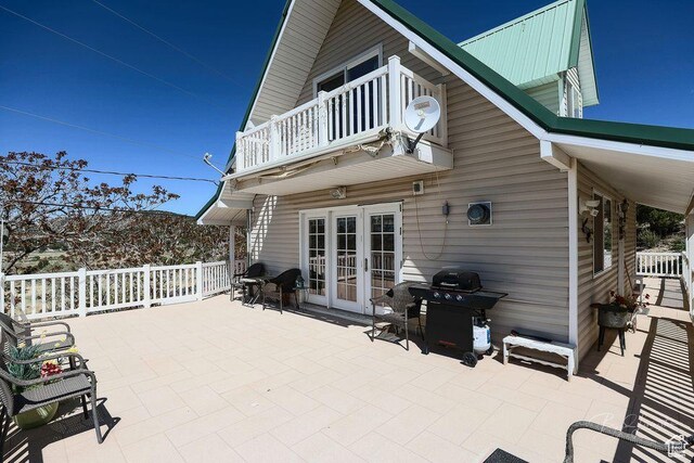view of patio / terrace featuring area for grilling, french doors, and a balcony