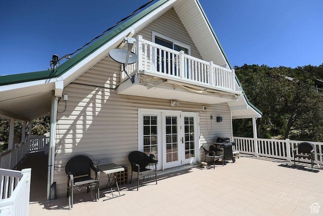 back of property with french doors, a patio area, and a balcony