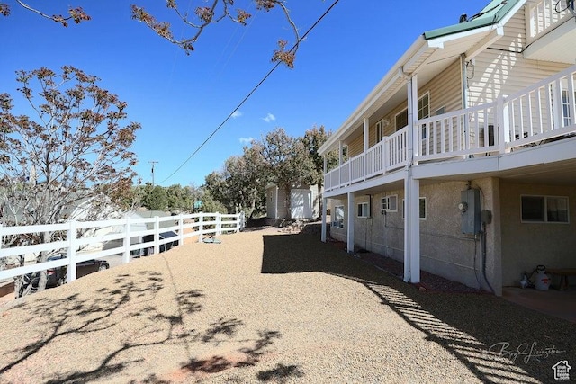 view of yard with fence and a balcony