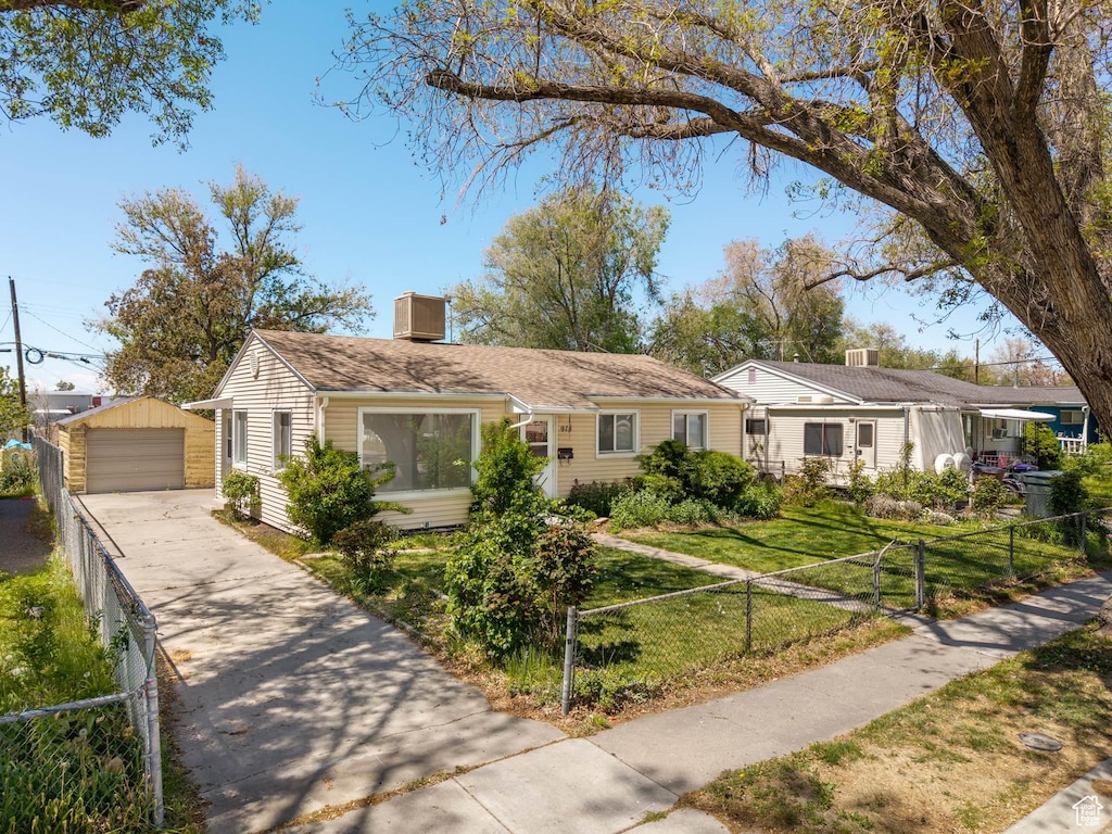 978 S Montgomery St, Salt Lake City, UT 84104 - view of front facade featuring fence private yard, a garage, an outbuilding, and driveway