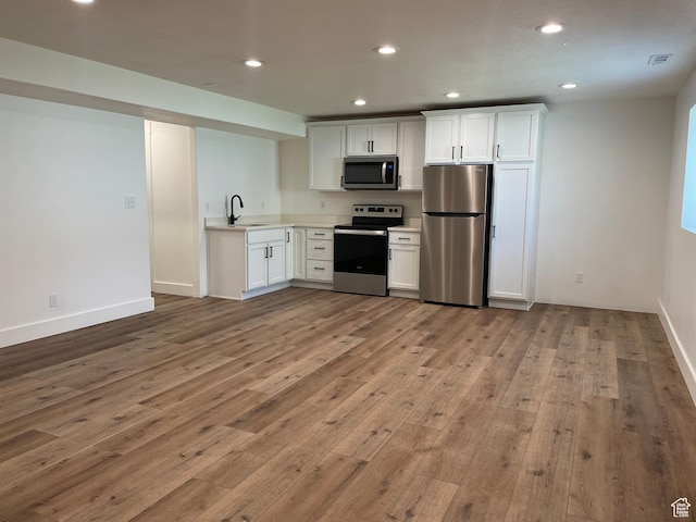 3834 N 2550 W, Farr West, UT 84404 - kitchen featuring stainless steel appliances, white cabinetry, light wood finished floors, light countertops, and recessed lighting