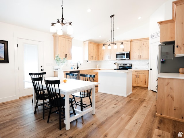 3834 N 2550 W, Farr West, UT 84404 - kitchen featuring appliances with stainless steel finishes, light brown cabinets, light countertops, a center island, and decorative backsplash