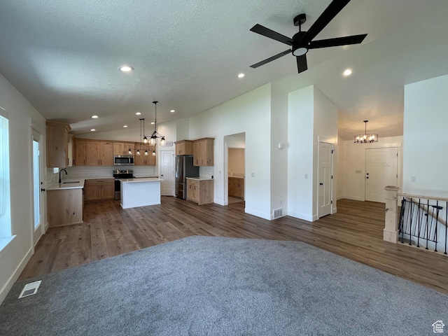 3834 N 2550 W, Farr West, UT 84404 - unfurnished living room with lofted ceiling, a chandelier, dark wood finished floors, recessed lighting, and ceiling fan