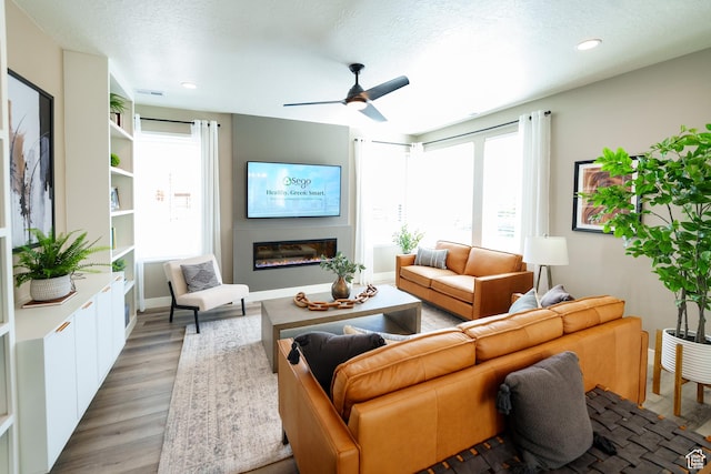 7093 W Granbury Dr S Unit 255, South Jordan, UT 84009 - living area featuring recessed lighting, ceiling fan, a glass covered fireplace, and light wood-type flooring