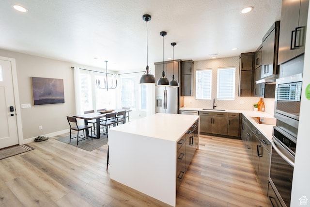 7093 W Granbury Dr S Unit 255, South Jordan, UT 84009 - kitchen featuring a sink, plenty of natural light, backsplash, and stainless steel appliances