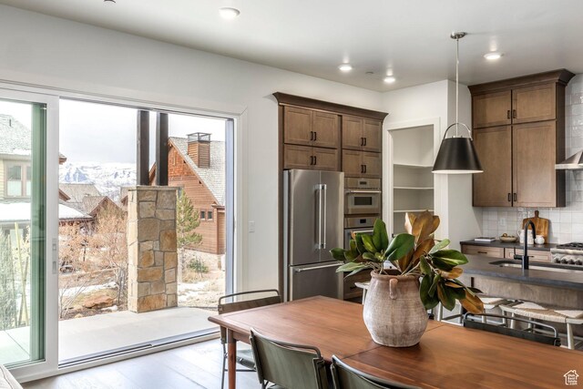 359 N Abajo Peak Loop E Unit A3, Heber City, UT 84032 - kitchen featuring decorative backsplash, high end refrigerator, wood finished floors, dark countertops, and a sink