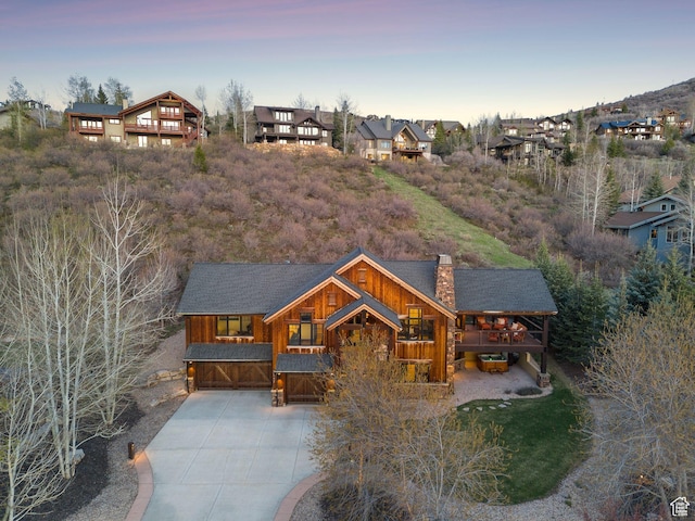 2042 Paddington Dr, Park City, UT 84060 - back of house featuring a chimney, driveway, a residential view, and an attached garage