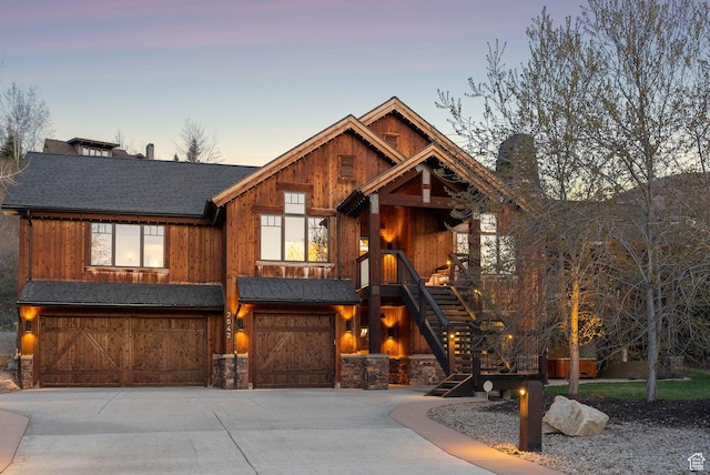 2042 Paddington Dr, Park City, UT 84060 - view of front facade featuring a garage, a shingled roof, concrete driveway, stone siding, and stairway