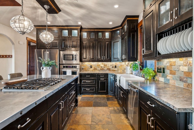 2042 Paddington Dr, Park City, UT 84060 - kitchen featuring a sink, stone tile floors, arched walkways, appliances with stainless steel finishes, and decorative backsplash