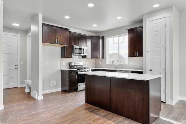 674 W Junegrass Ln, Stansbury Park, UT 84074 - kitchen featuring decorative backsplash, appliances with stainless steel finishes, wood finished floors, and dark brown cabinets