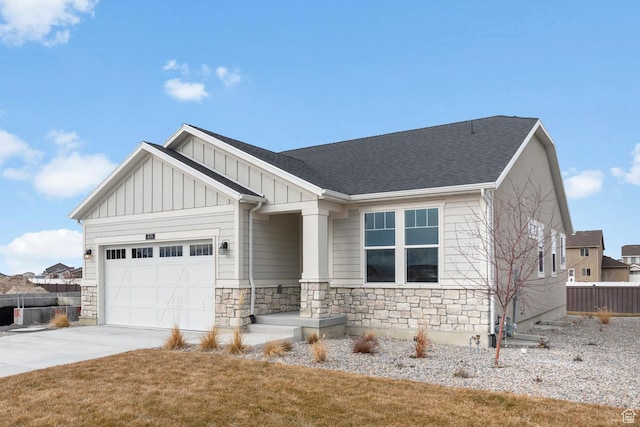 674 W Junegrass Ln, Stansbury Park, UT 84074 - view of front of home featuring fence, stone siding, a garage, board and batten siding, and driveway