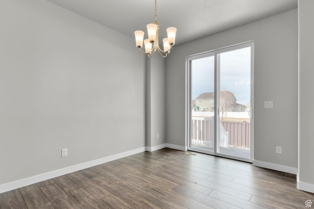 674 W Junegrass Ln, Stansbury Park, UT 84074 - spare room with baseboards, wood finished floors, and a chandelier