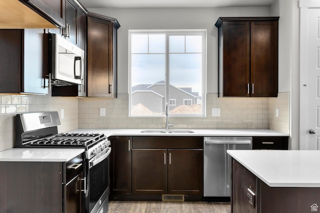 674 W Junegrass Ln, Stansbury Park, UT 84074 - kitchen featuring a sink, appliances with stainless steel finishes, dark brown cabinetry, and visible vents
