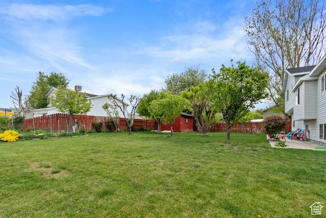 3184 W 5025 S, Roy, UT 84067 - view of yard featuring an outdoor structure, a patio, a fenced backyard, and a storage unit