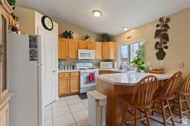 3184 W 5025 S, Roy, UT 84067 - kitchen featuring a peninsula, a breakfast bar, white appliances, light countertops, and a sink