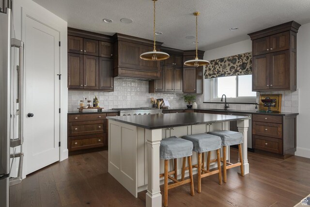 1478 W 400 N, West Bountiful, UT 84087 - kitchen featuring high end refrigerator, custom exhaust hood, dark countertops, a sink, and dark wood finished floors