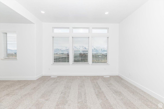 carpeted spare room featuring baseboards