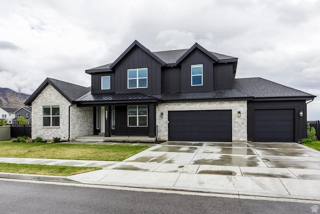 5081 W Sequoia Cir, Highland, UT 84003 - view of front of home with covered porch, a standing seam roof, driveway, a front yard, and stone siding