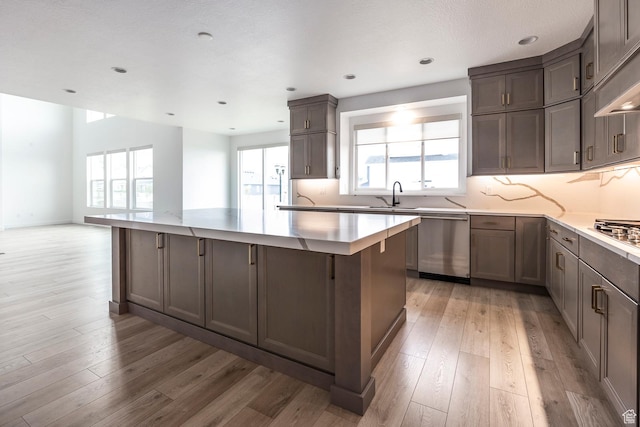 5081 W Sequoia Cir, Highland, UT 84003 - kitchen with a large island, tasteful backsplash, a sink, stainless steel appliances, and light wood-style flooring