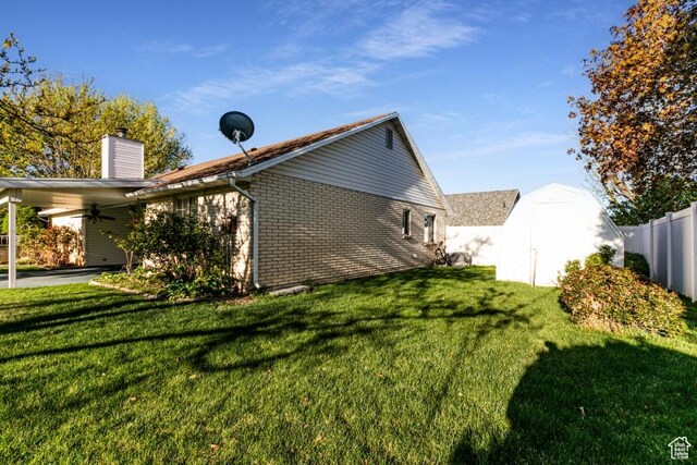 954 E 5650 S, South Ogden, UT 84405 - view of side of property with a ceiling fan, a chimney, a lawn, brick siding, and a shed