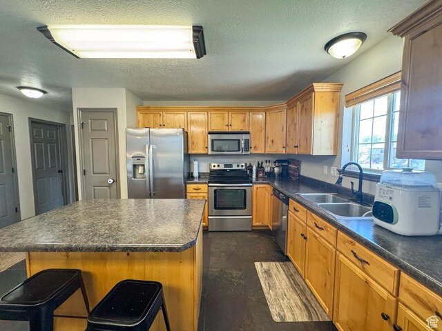 3261 S 1500 W, Nibley, UT 84321 - kitchen featuring a sink, a textured ceiling, dark countertops, and stainless steel appliances
