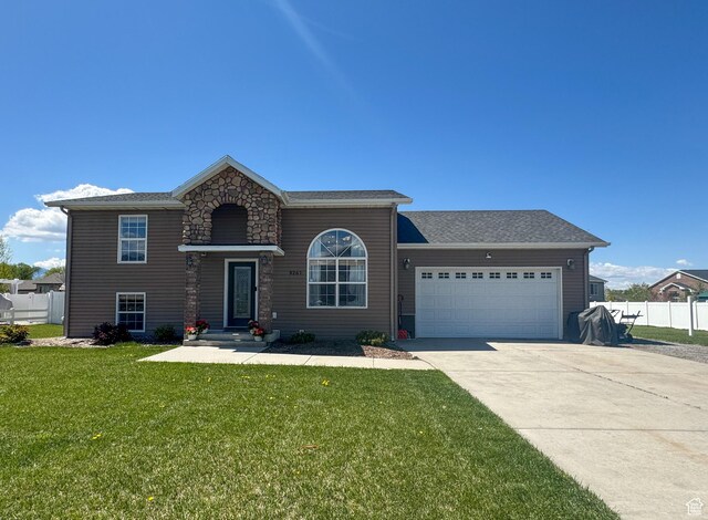 3261 S 1500 W, Nibley, UT 84321 - view of front of house with concrete driveway, fence, a front yard, and a garage