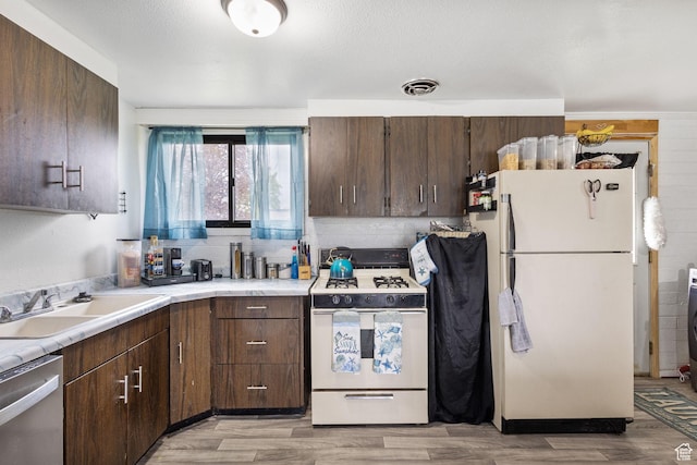 472 E Marva Ave, Layton, UT 84041 - kitchen with white appliances, a sink, light countertops, and light wood-type flooring
