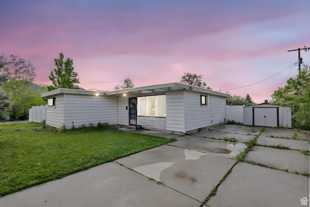 ranch-style house featuring a front yard, an outbuilding, fence, a shed, and a patio