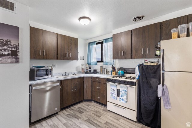 472 E Marva Ave, Layton, UT 84041 - kitchen featuring stainless steel appliances, dark brown cabinets, light countertops, and a sink