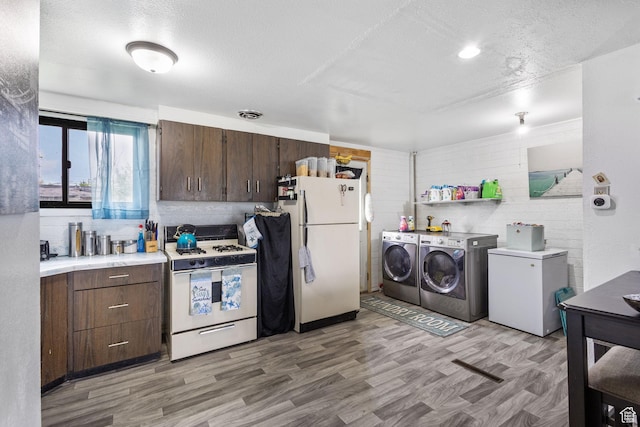 472 E Marva Ave, Layton, UT 84041 - kitchen with white appliances, washer and clothes dryer, light countertops, light wood finished floors, and dark brown cabinets
