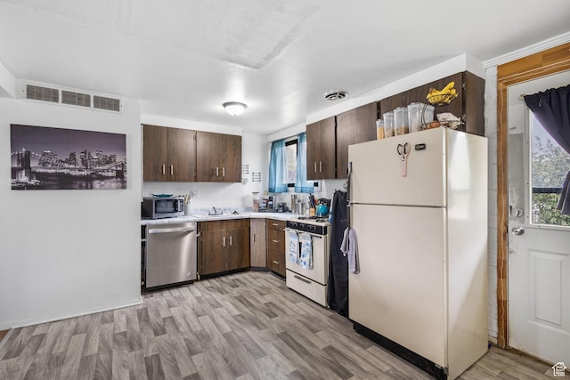 472 E Marva Ave, Layton, UT 84041 - kitchen with stainless steel appliances, dark brown cabinets, light countertops, light wood-style flooring, and a sink