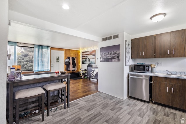 472 E Marva Ave, Layton, UT 84041 - kitchen featuring appliances with stainless steel finishes, a sink, dark brown cabinetry, and light wood finished floors