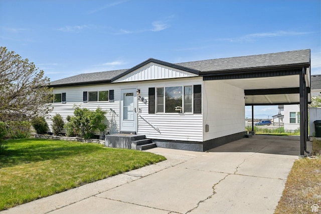 view of front of home featuring a shingled roof, a front lawn, driveway, and a carport