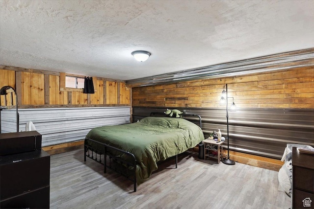 968 Bel Mar Dr, Ogden, UT 84403 - bedroom featuring light wood-style floors, wood walls, a textured ceiling, and baseboards