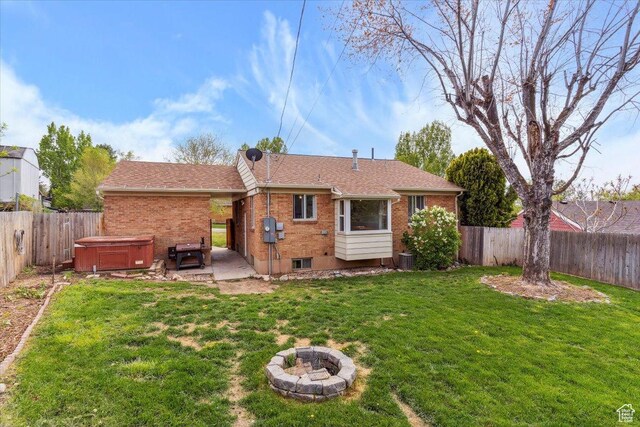 968 Bel Mar Dr, Ogden, UT 84403 - back of property with a hot tub, a lawn, a fenced backyard, and a patio area