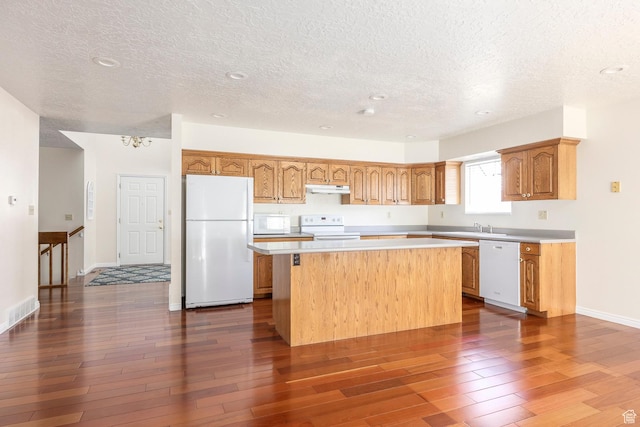 176 N 170 E, Orem, UT 84057 - kitchen featuring white appliances, a center island, light countertops, a textured ceiling, and under cabinet range hood