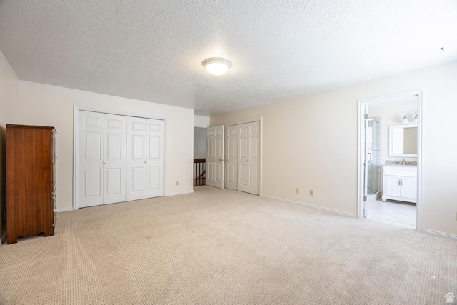176 N 170 E, Orem, UT 84057 - unfurnished bedroom featuring connected bathroom, light colored carpet, a sink, two closets, and baseboards