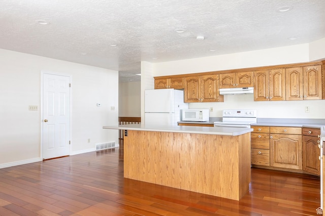 176 N 170 E, Orem, UT 84057 - kitchen featuring white appliances, a textured ceiling, under cabinet range hood, visible vents, and a kitchen island