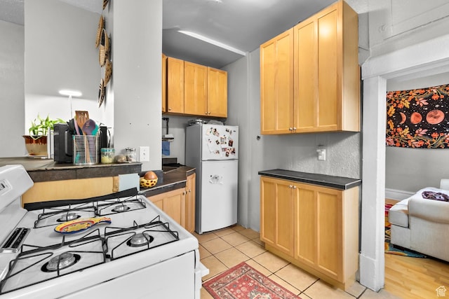 1470 S Edison St, Salt Lake City, UT 84115 - kitchen with white appliances, dark countertops, light tile patterned floors, and light brown cabinets
