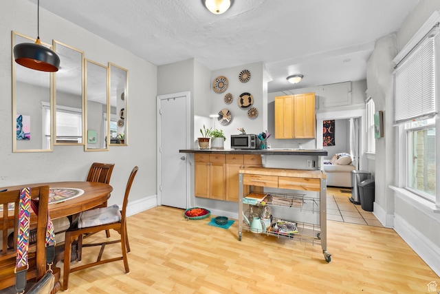 1470 S Edison St, Salt Lake City, UT 84115 - kitchen featuring light brown cabinetry, stainless steel microwave, baseboards, and light wood finished floors