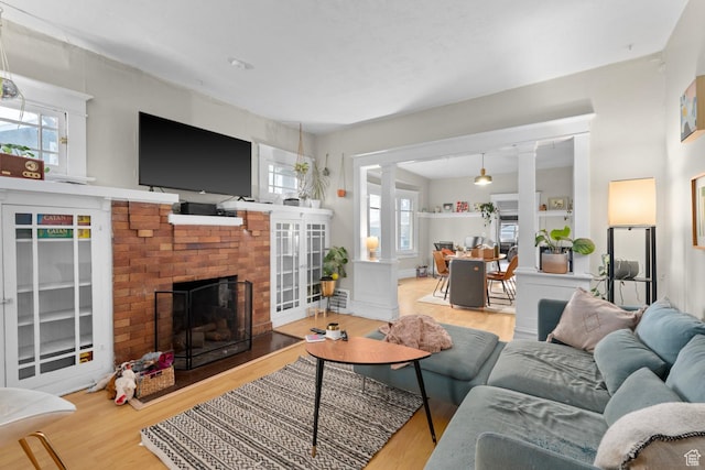 1470 S Edison St, Salt Lake City, UT 84115 - living room with a fireplace, ornate columns, and wood finished floors