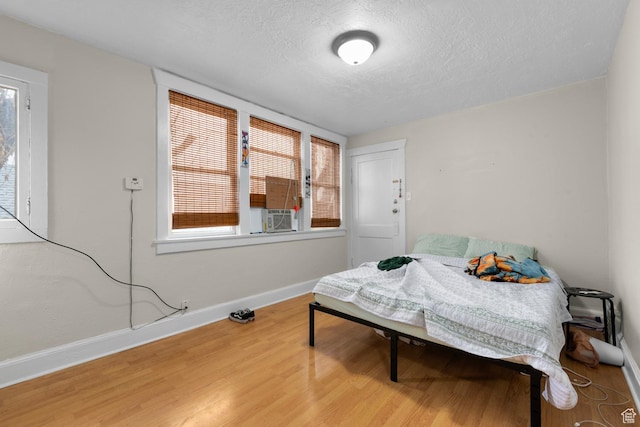1470 S Edison St, Salt Lake City, UT 84115 - bedroom featuring baseboards, a textured ceiling, wood finished floors, and multiple windows