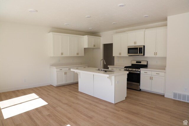 3743 N Janie St Unit 1010, Eagle Mountain, UT 84005 - kitchen featuring visible vents, light wood-style floors, an island with sink, a sink, and appliances with stainless steel finishes