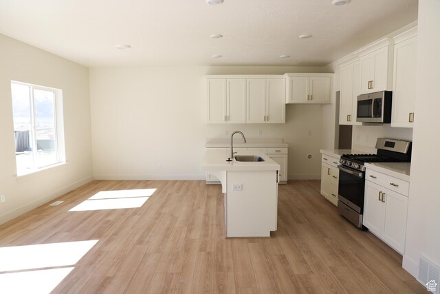 3743 N Janie St Unit 1010, Eagle Mountain, UT 84005 - kitchen with appliances with stainless steel finishes, a sink, light wood-style floors, light countertops, and white cabinetry