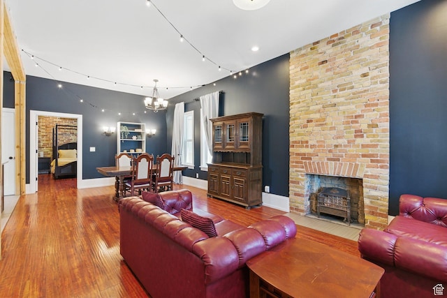 775 E Simpson Ave, Salt Lake City, UT 84106 - living area featuring baseboards, a brick fireplace, wood finished floors, and a chandelier