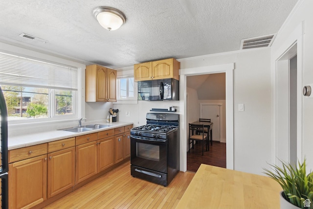 775 E Simpson Ave, Salt Lake City, UT 84106 - kitchen with visible vents, light wood-type flooring, a sink, light countertops, and black appliances