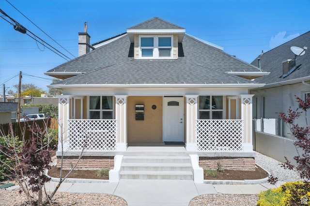 775 E Simpson Ave, Salt Lake City, UT 84106 - view of front of home featuring a porch, fence, a chimney, and roof with shingles